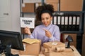 Young african american woman working at small business ecommerce holding thank you banner smiling happy pointing with hand and Royalty Free Stock Photo