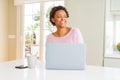 Young african american woman working using computer laptop looking away to side with smile on face, natural expression Royalty Free Stock Photo