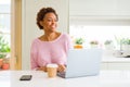 Young african american woman working using computer laptop looking away to side with smile on face, natural expression Royalty Free Stock Photo