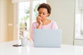 Young african american woman working using computer laptop looking stressed and nervous with hands on mouth biting nails Royalty Free Stock Photo