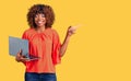 Young african american woman working using computer laptop smiling happy pointing with hand and finger to the side Royalty Free Stock Photo