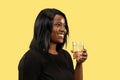 Young african woman on yellow studio background, facial expression