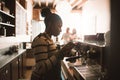 Young African barista frothing milk behind a cafe counter Royalty Free Stock Photo