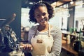 Smiling young African barista preparing fresh coffee in a cafe Royalty Free Stock Photo