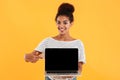 Young beautiful lady with curly hair showing laptop computer isolated Royalty Free Stock Photo