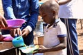 A young African boy being served food at a school feeding programme