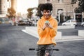 Young african boy with bike listening music with headphones outdoors - Focus on face Royalty Free Stock Photo