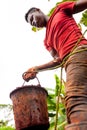 Young african boy with bucket full of soil during manual digging of water well in african country