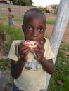 Young African boy eating pomegranate fruit.