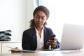 Young african business woman sitting at her desk and reviewing documents