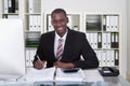 Smiling Male Accountant Writing On Documents