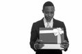 Young African businessman opening gift box and looking surprised Royalty Free Stock Photo