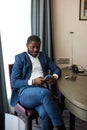 Young african businessman sitting on chair in hotel Royalty Free Stock Photo