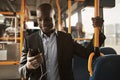 Young African businessman standing on a bus listening to music Royalty Free Stock Photo