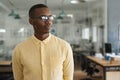 Young African businessman thinking about work while standing in an office Royalty Free Stock Photo