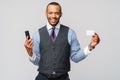 A young African businessman using his smartphone to shop online while holding his credit card Royalty Free Stock Photo