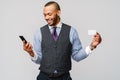 A young African businessman using his smartphone to shop online while holding his credit card Royalty Free Stock Photo