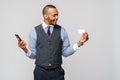 A young African businessman using his smartphone to shop online while holding his credit card Royalty Free Stock Photo