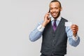 A young African businessman using his smartphone to shop online while holding his credit card Royalty Free Stock Photo