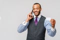 A young African businessman using his smartphone to shop online while holding his credit card Royalty Free Stock Photo