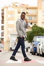 Young african businessman walking and talking on cell phone in the city Royalty Free Stock Photo