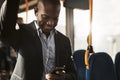 Smiling African businessman riding on a bus listening to music Royalty Free Stock Photo