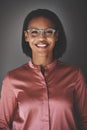 Young African businesswoman smiling while standing against a gra Royalty Free Stock Photo
