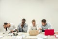 Young men and women sitting at office and working on laptops. Emotions concept