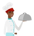 Young african chef holding towel and cloche.