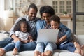 Young African couple and children sitting on sofa with laptop Royalty Free Stock Photo