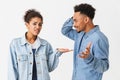 Young african couple in denim shirts quarrels between themselves