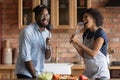 Young african couple sing song in microphones of kitchen utensils