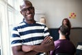 Smiling African designer standing in an office after a meeting