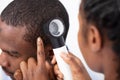 Doctor Examining Man`s Hair With Dermatoscope