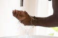 Young african ethnicity man washing hands under tap water.
