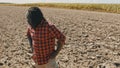 Young african farmer standing on the agricultural plowed land