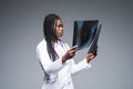 Young african Female doctor looking at an x-ray  on gray background Royalty Free Stock Photo