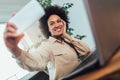 Young African female entrepreneur sitting at a desk in her home office make selfie photo Royalty Free Stock Photo