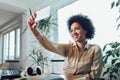 Young African female entrepreneur sitting at a desk in her home office make selfie photo Royalty Free Stock Photo