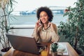 Young African female entrepreneur sitting at a desk in her home office working online with a laptop Royalty Free Stock Photo