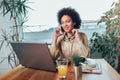 Young African female entrepreneur sitting at a desk in her home office working online with a laptop Royalty Free Stock Photo