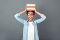 Young african woman isolated on grey wall studio casual daily lifestyle student holding a pile of books Royalty Free Stock Photo