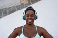 Young African fit woman listening music with headphones during workout session outdoor Royalty Free Stock Photo