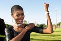 Young African girl flexing arm muscles in show of feminist power