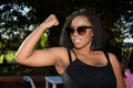 Young African girl flexing arm muscles in show of feminist power