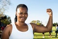 Young African girl flexing arm muscles in show of feminist power