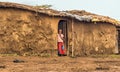 Young african girl from masai tribe in the doorway of her home