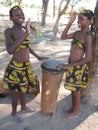 Young African girls in cultural attire playing drums