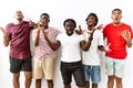 Young african group of friends standing together over isolated background crazy and mad shouting and yelling with aggressive Royalty Free Stock Photo