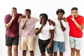 Young african group of friends standing together over isolated background hand on mouth telling secret rumor, whispering malicious Royalty Free Stock Photo
